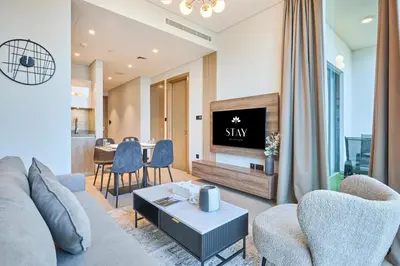 a living room with a couch and a tv at STAY BY LATINEM Luxury 1BR Holiday Home W706 Near Burj Khalifa in Dubai
