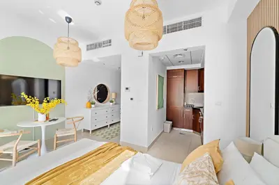 a room with a bed and a dining room at Silkhaus Modern Studio with Burj Khalifa View in Dubai