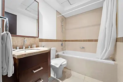 a bathroom with a tub and a toilet and a sink at Silkhaus Modern Studio with Burj Khalifa View in Dubai
