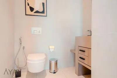 a white bathroom with a toilet and a sink at Luxury Beachfront 1BR Jumeirah Gate Tower 1 By ĀYA Boutique in Dubai