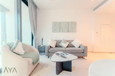a living room with a couch and a table at Luxury Beachfront 1BR Jumeirah Gate Tower 1 By ĀYA Boutique in Dubai