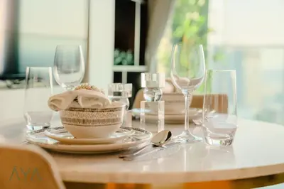 a table with glasses and a bowl of food on it at Luxury Beachfront 1BR Jumeirah Gate Tower 1 By ĀYA Boutique in Dubai