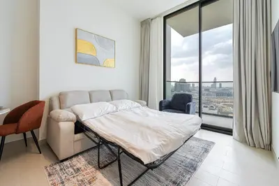 a bedroom with a bed and a large window at Smart living I High speed wi-fi I City view in Dubai