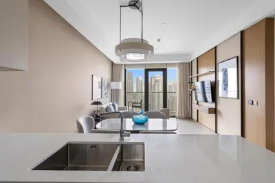 a kitchen with a sink and a living room at 2BR Address Opera, Full Burj Khalifa View in Dubai