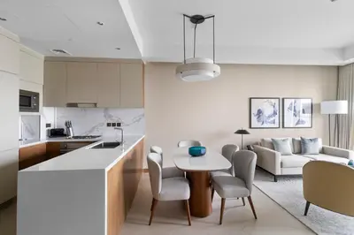a kitchen and living room with a table and chairs at 2BR Address Opera, Full Burj Khalifa View in Dubai