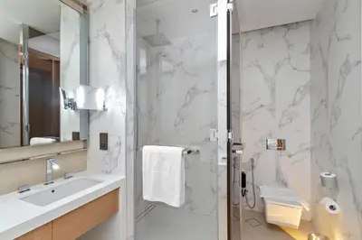 a bathroom with a shower and a sink and a mirror at 2BR Address Opera, Full Burj Khalifa View in Dubai