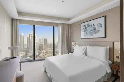 a bedroom with a white bed and a large window at 2BR Address Opera, Full Burj Khalifa View in Dubai