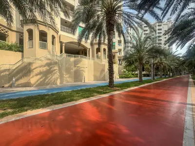 a street with palm trees in front of a building at Cosy Palm Jumeirah 1 Bedroom - Perfect Location in Dubai