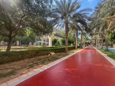 a red road in front of a building with palm trees at Cosy Palm Jumeirah 1 Bedroom - Perfect Location in Dubai