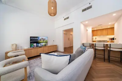a living room with a couch and a kitchen at Cosy Palm Jumeirah 1 Bedroom - Perfect Location in Dubai