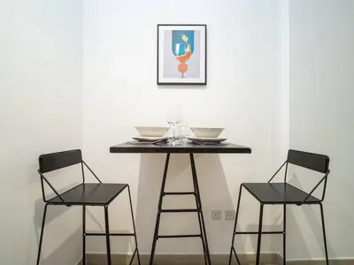 a table with two chairs and a table with glasses on it at Stylish Studio Living in the Heart of JVC in Dubai