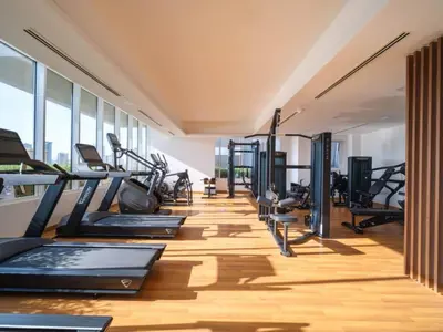 a gym with a row of treadmills and elliptical machines at Stylish Studio Living in the Heart of JVC in Dubai