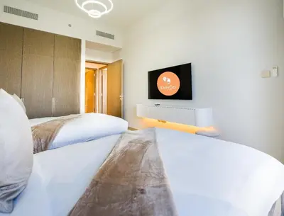 two beds in a room with a tv on the wall at EasyGo-Core Luxury 2BDR in Grande Signature Res panoramic view in Dubai