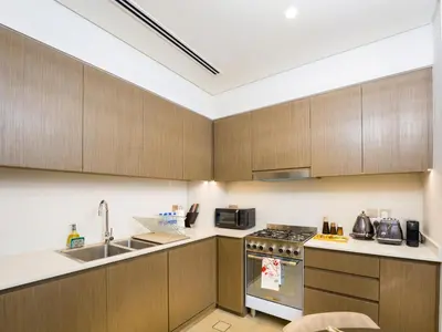 a kitchen with wooden cabinets and a sink at EasyGo-Core Luxury 2BDR in Grande Signature Res panoramic view in Dubai