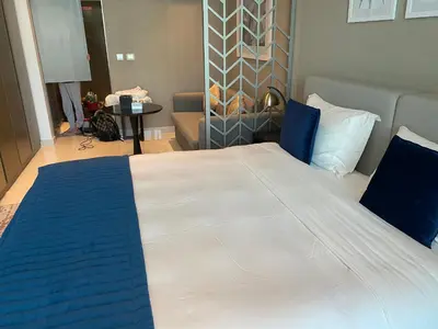 a bedroom with a large bed with blue and white sheets at Luxurious studio in Damac maison prive by Phineek vacation home in Dubai