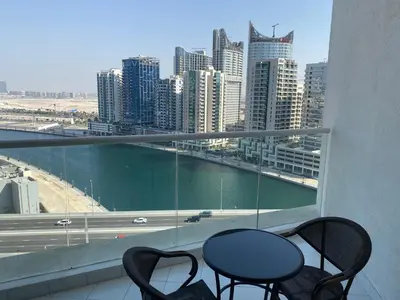 a table and chairs on a balcony with a view of a city at Luxurious studio in Damac maison prive by Phineek vacation home in Dubai