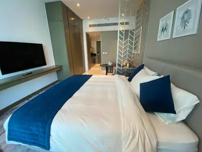 a bedroom with a large bed with a flat screen tv at Luxurious studio in Damac maison prive by Phineek vacation home in Dubai