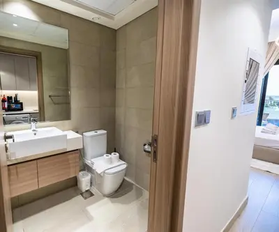 a bathroom with a toilet and a sink and a mirror at Elite LUX Holiday Homes - Upscale Studio in Azizi Riviera Prime Location Dubai in Dubai