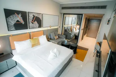 a bedroom with a white bed and a living room at Stylish Studio, MAG 318 in Dubai