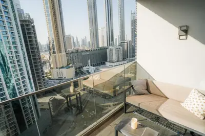 a balcony with a couch and a view of a city at Stylish Studio, MAG 318 in Dubai