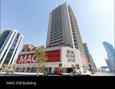 a large building with a sign on it in a city at Stylish Studio, MAG 318 in Dubai
