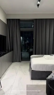 a bedroom with a bed and a large window at Stylish Studio, MAG 318 in Dubai