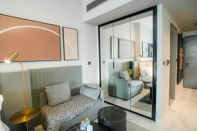 a living room with a chair and a mirror at Stylish Studio, MAG 318 in Dubai