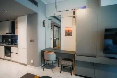 a kitchen with a desk and chairs in a room at Stylish Studio, MAG 318 in Dubai