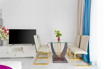 a living room with a glass table and chairs at Vacay Lettings - Pearlz By Danube -Studio-Al Furjan-Near Metro in Dubai