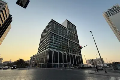 a tall building on a city street with a traffic light at Cozy 1BR with balcony in Binghatti Emerald in Dubai
