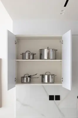 a kitchen with pots and pans on a shelf at Cozy 1BR with balcony in Binghatti Emerald in Dubai