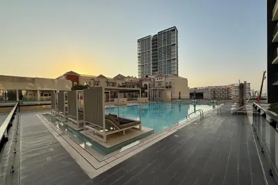 a swimming pool on the roof of a building at Cozy 1BR with balcony in Binghatti Emerald in Dubai