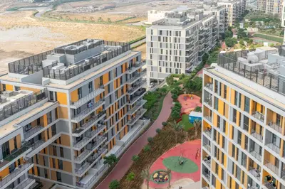 an aerial view of buildings and a park at Vacay Lettings - Spacious Studio Apartment - Production City in Dubai