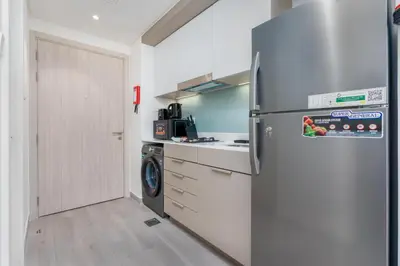 a kitchen with a stainless steel refrigerator and a dishwasher at Vacay Lettings - Spacious Studio Apartment - Production City in Dubai