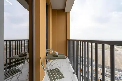 a balcony with two chairs and a table on it at Vacay Lettings - Spacious Studio Apartment - Production City in Dubai