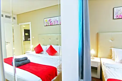 a bedroom with two beds with red pillows at Luxurious 1bhk in Cour Jardin in Dubai