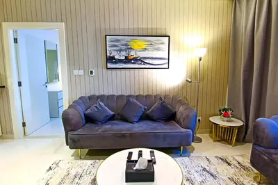 a living room with a couch and a table at Luxurious 1bhk in Cour Jardin in Dubai