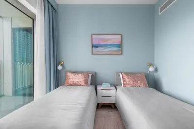 two beds in a room with a window at Front Row Burj Khalifa Views - Dubai Mall Access - Premium 2BDR in Dubai