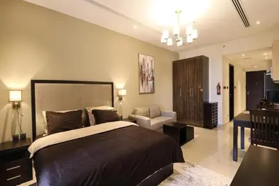 a bedroom with a large bed and a desk at Luxurious Elite Studio-DownTown in Dubai