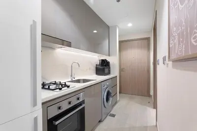 a kitchen with a sink and a washing machine at Sleek Studio Apartment in Azizi Riviera in Dubai
