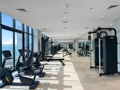 a gym with treadmills and ellipticals in a building at Sleek Studio Apartment in Azizi Riviera in Dubai