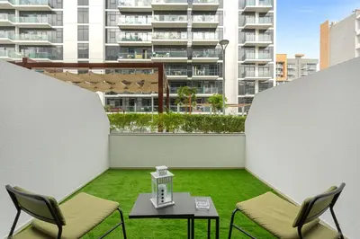 a balcony with a table and chairs and a building at Sleek Studio Apartment in Azizi Riviera in Dubai