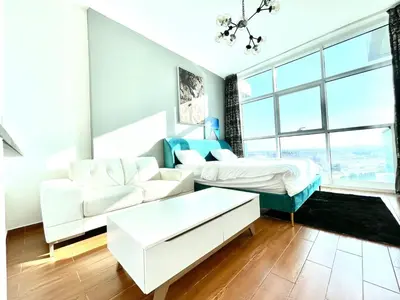 a living room with a couch and a bed at Studio apartment in jumeriah village triangle district 2 in Dubai