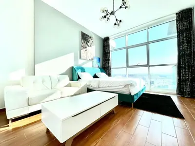 a living room with a couch and a bed at Studio apartment in jumeriah village triangle district 2 in Dubai