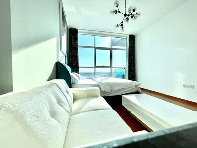 a bedroom with two beds and a large window at Studio apartment in jumeriah village triangle district 2 in Dubai