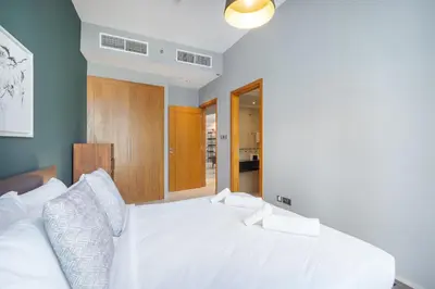 a bedroom with a bed with white sheets and pillows at Premium 2 Bedroom in Trident Residence JBR in Dubai