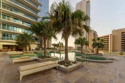 a courtyard with palm trees in front of a building at Premium 2 Bedroom in Trident Residence JBR in Dubai