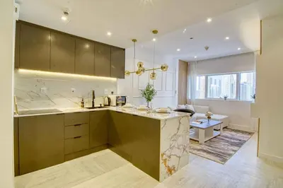 a kitchen with a counter and a living room at Dubai Gate 1 in Dubai