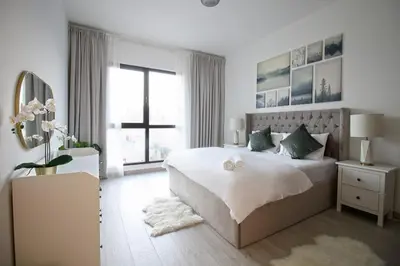 a white bedroom with a large bed and a window at 1 Bedroom Apartment with Burj AlArab View from your Balcony R507 in Dubai