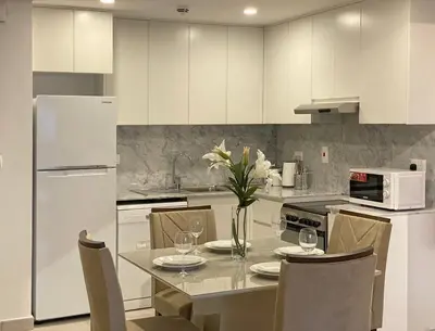 a kitchen with a table with a vase of flowers on it at 1 Bedroom Apartment with Burj AlArab View from your Balcony R507 in Dubai